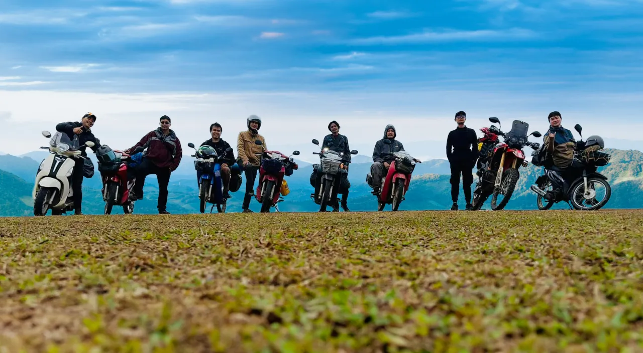 a group of people standing next to each other on top of a hill