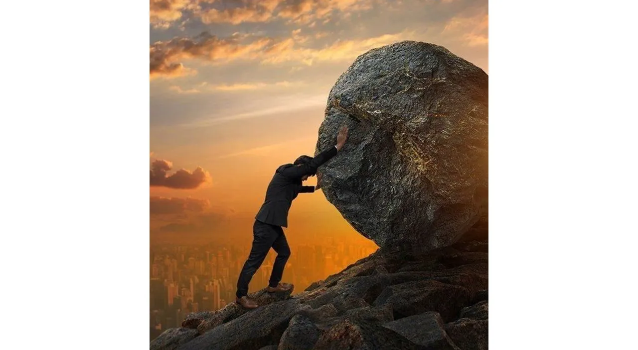 a man pushing a large rock up into the air