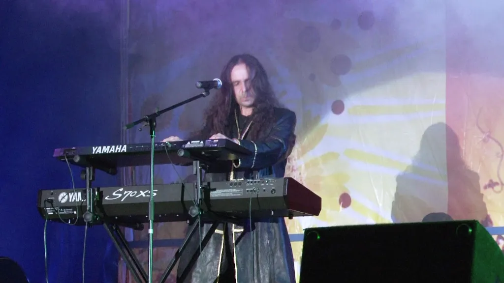 a man standing at a keyboard on a stage