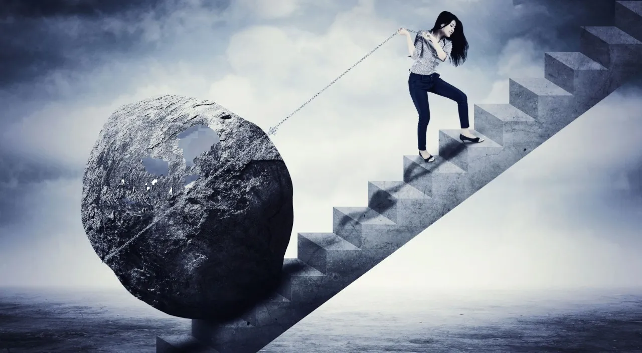 a woman pulling a rope with rock down a stairway