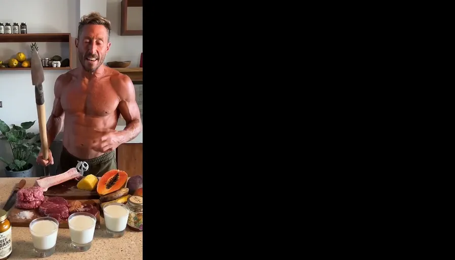 a shirtless man standing in front of a cutting board