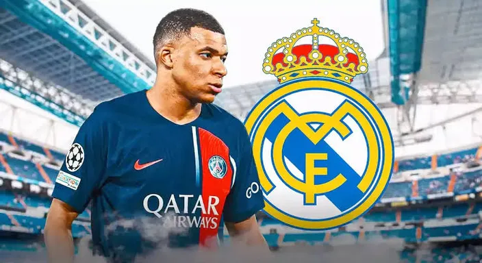 Mbappe standing in front of a real madrid logo