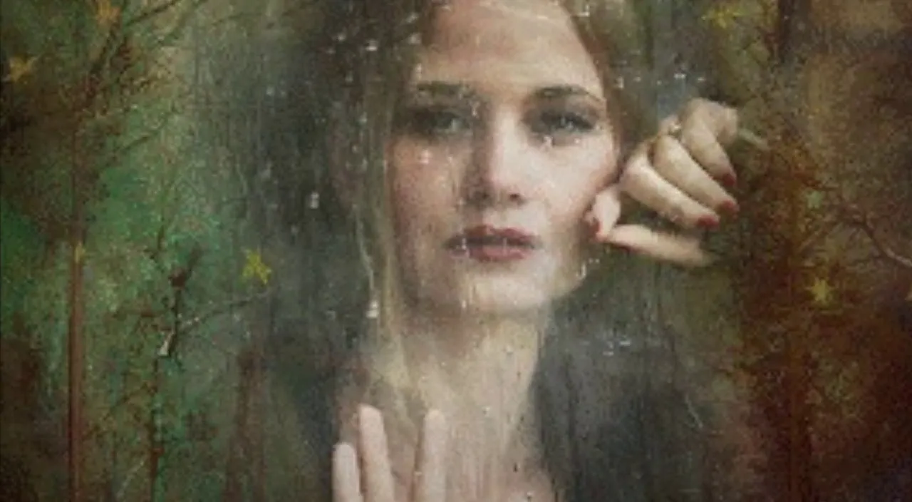 a woman standing in front of a window holding her hand up to her face