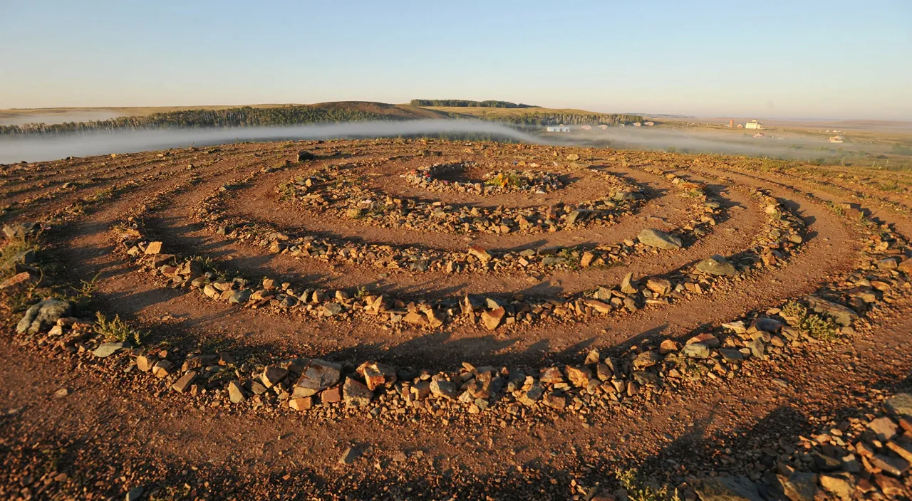 a spiral of rocks in the middle of a field