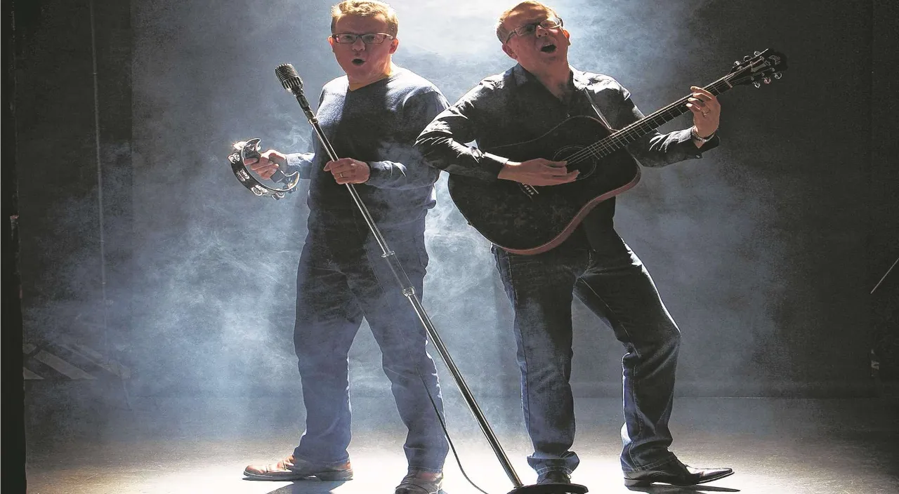 a couple of men standing next to each other holding guitars