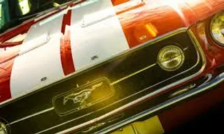 a close up of the front of a red and white mustang