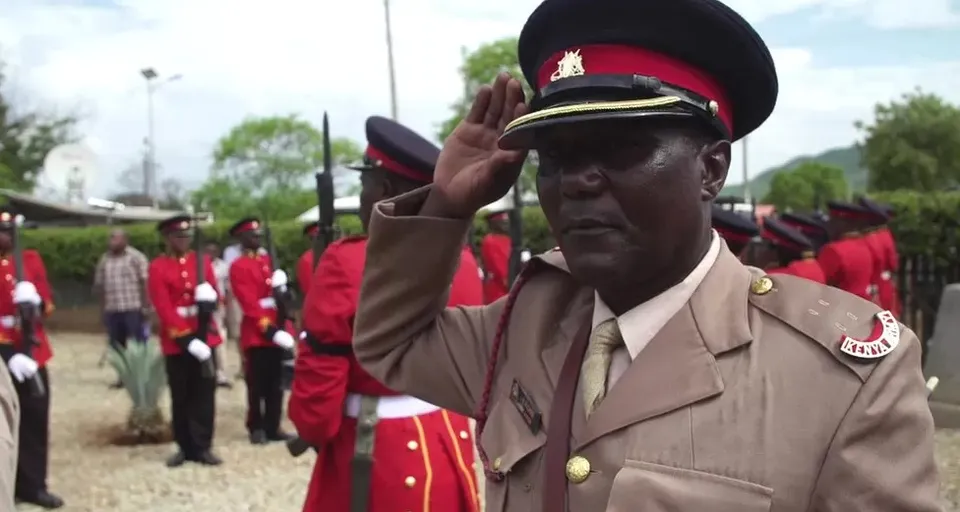 a man in a uniform saluting a group of people