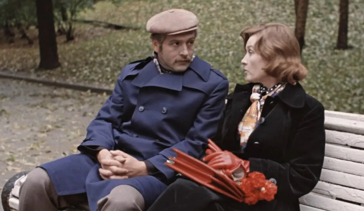 a man and a woman sitting on a park bench