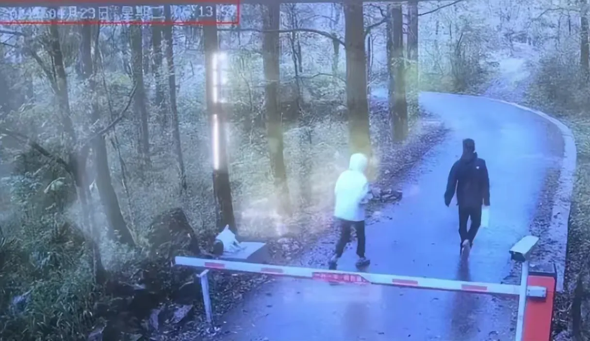 a man and a woman walking down a path in the woods