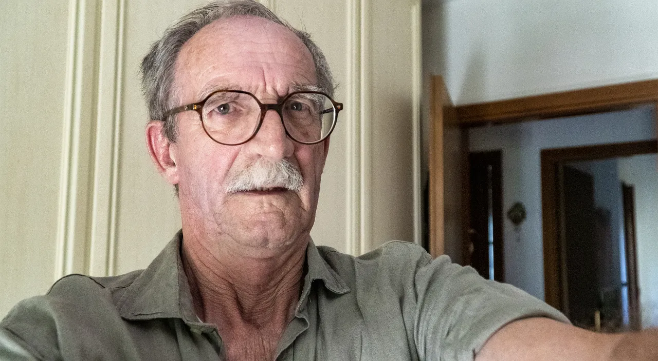 a man with a mustache and glasses is taking a selfie