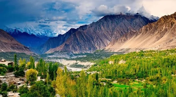 a scenic view of a valley with mountains in the background