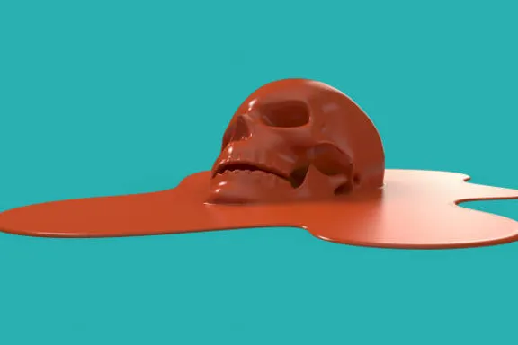 a fake skull sitting on top of a spilled orange liquid