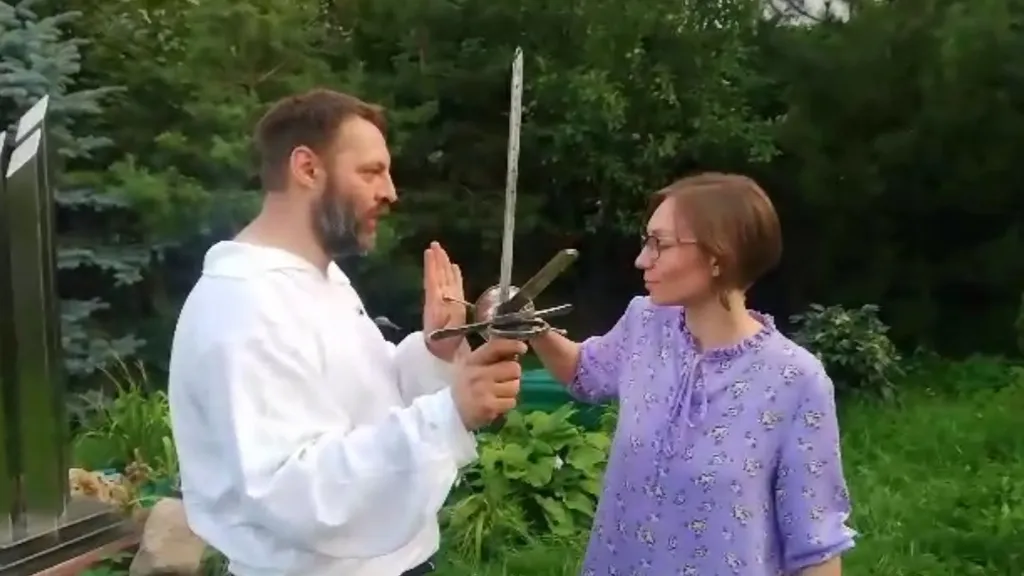 a man holding a pair of scissors next to a woman