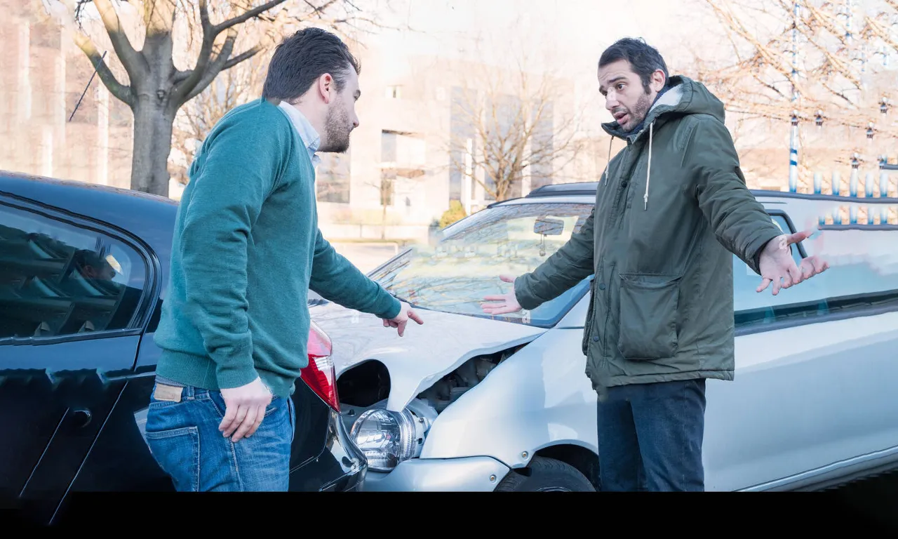 a couple of men standing next to a car accident, night time