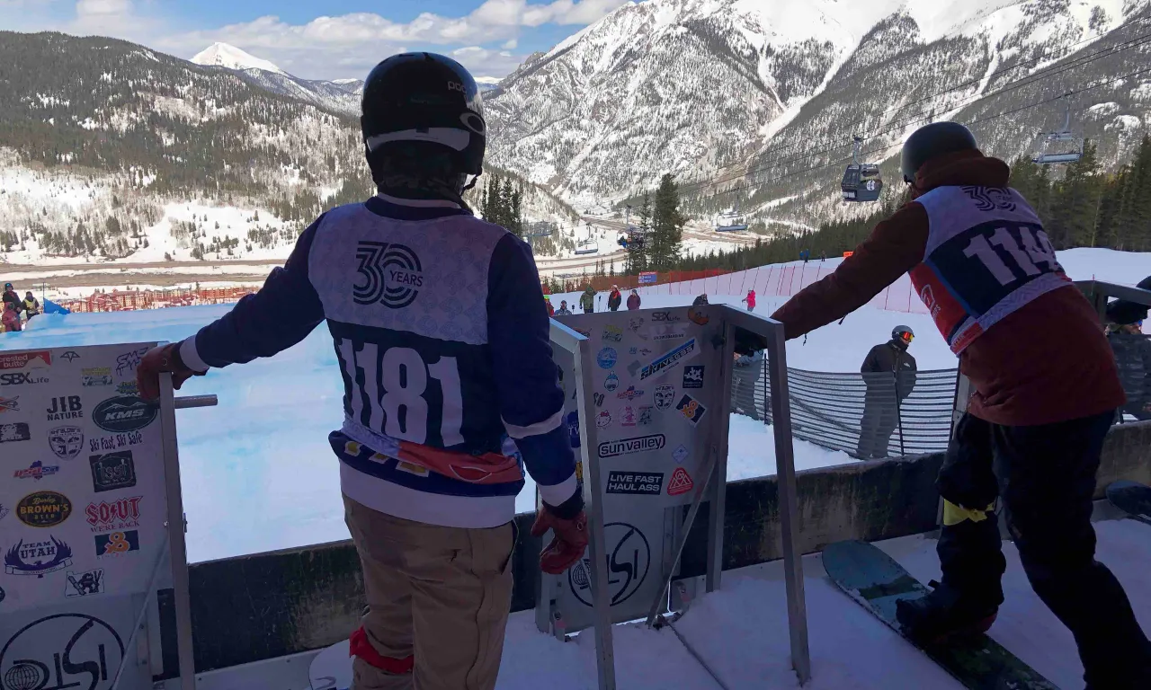 They lined up at the starting gate, eyeing each other with a mix of respect and rivalry.  person on a snowboard on a snowy slope