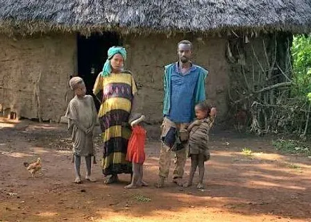 a group of people standing in front of a hut