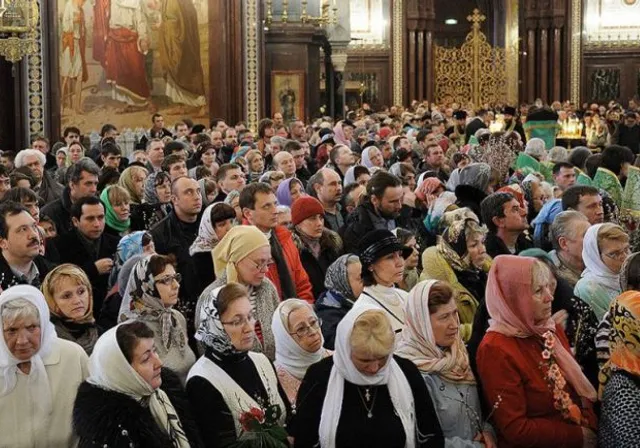 many smiling and dancing people in Slavic Church looling like colorful discoteque inside