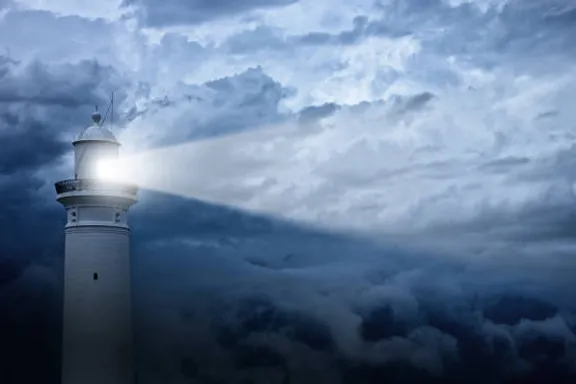 a lighthouse in the middle of a cloudy sky