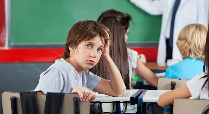 a group of children sitting at desks in a classroom