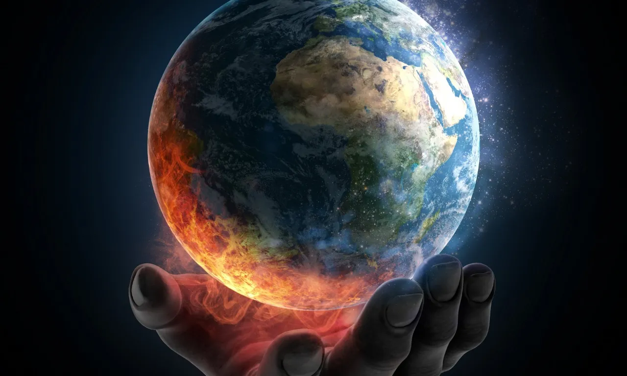 a hand holding the earth in flames