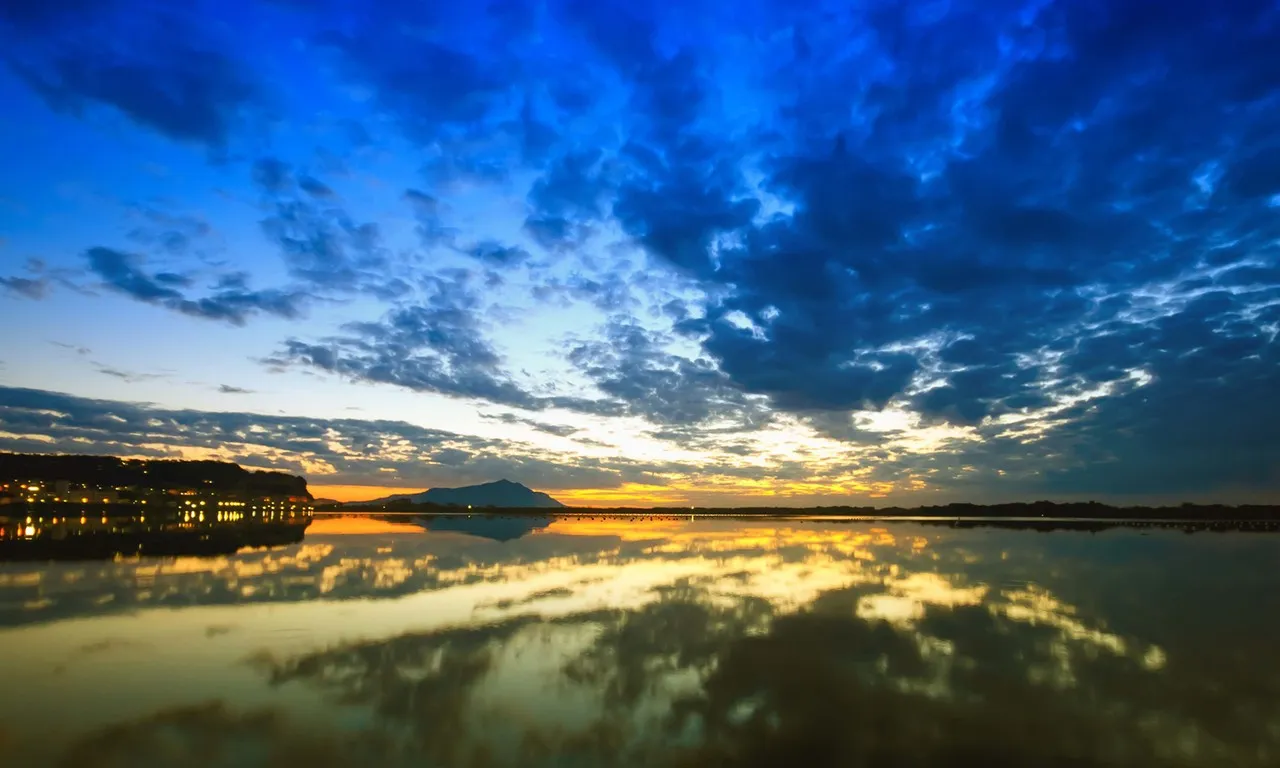 the sky is reflected in the still water of the lake