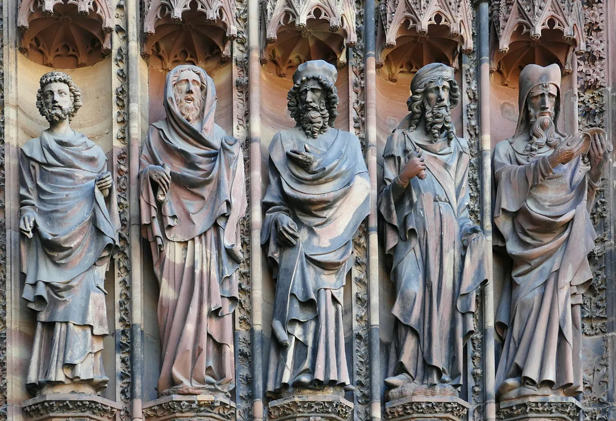 a group of statues on the side of a building coming to life