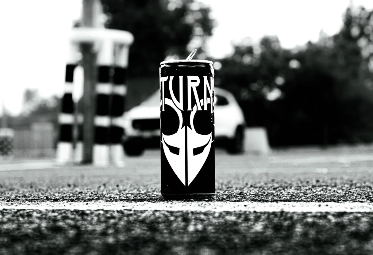 a black and white photo of a can of drink