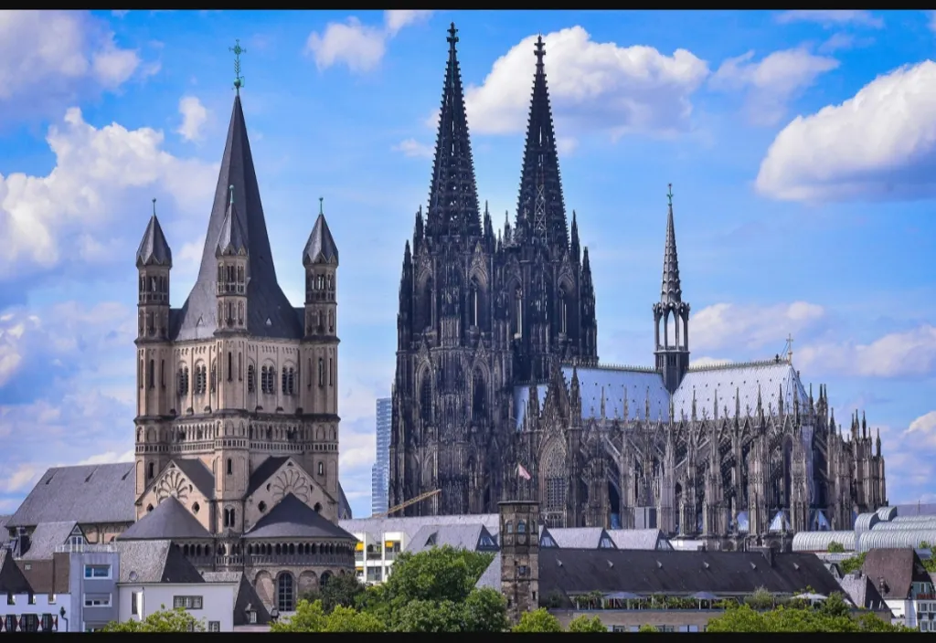 a large cathedral towering over a city under a blue sky