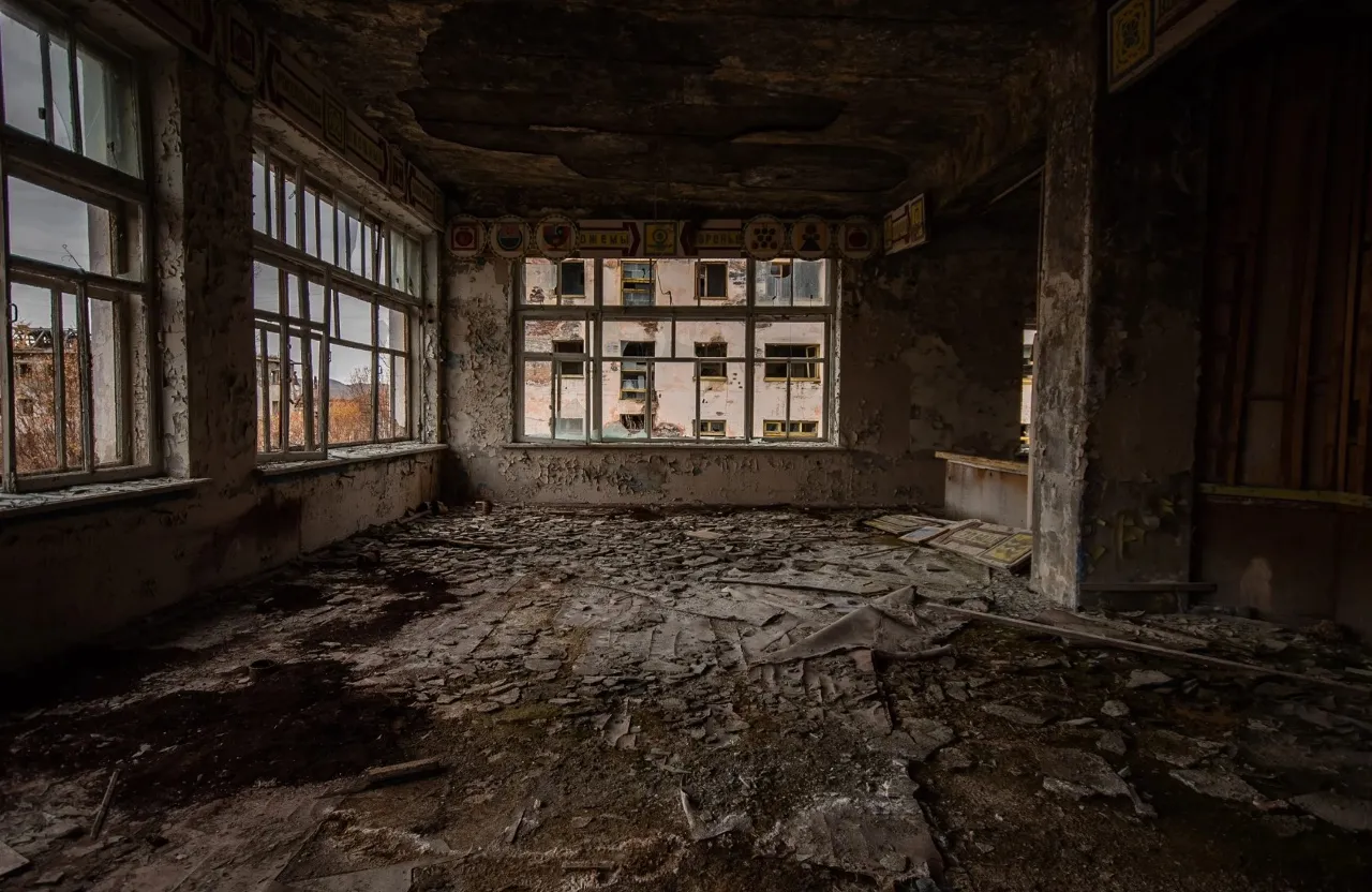 a run down room with broken windows and debris on the floor