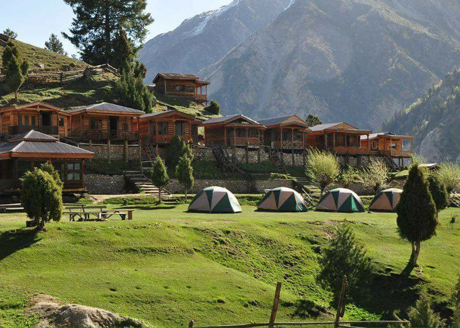 a group of tents sitting on top of a lush green hillside