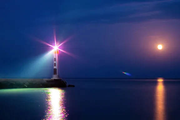 a light house sitting in the middle of a body of water