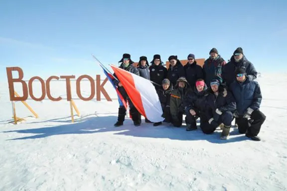 a group of people standing on top of a snow covered slope