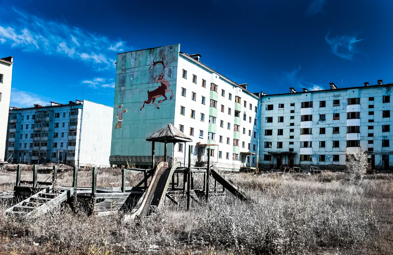 an abandoned building with a slide in front of it