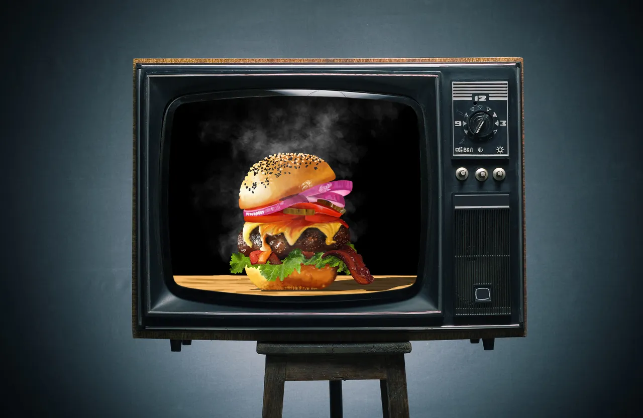 Static TV stands on a chair.  They're advertising HAMBURGER.