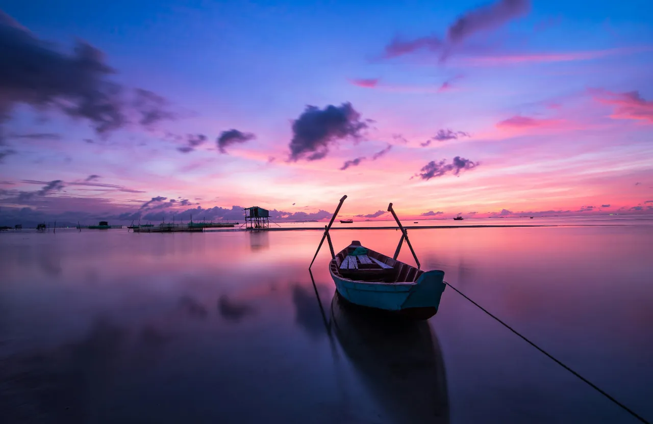 a small boat sitting on top of a body of water