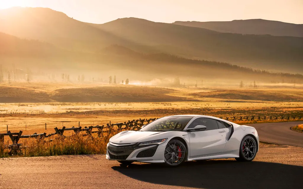 a white sports car parked on the side of a road