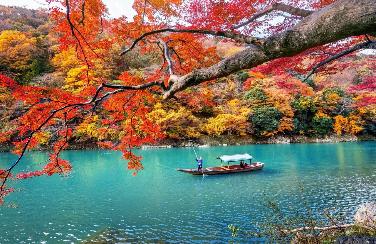 a boat floating on top of a lake surrounded by trees