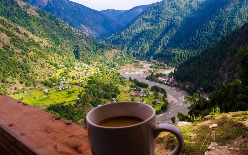 a cup of coffee sitting on top of a wooden table