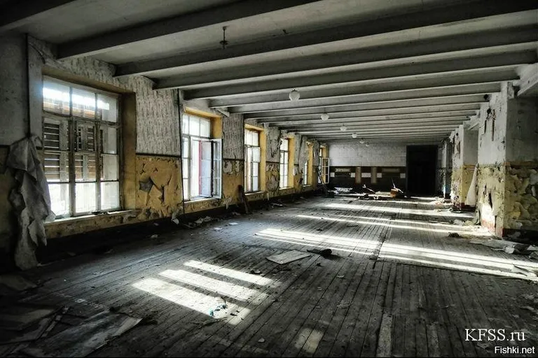 an empty room with wooden floors and windows