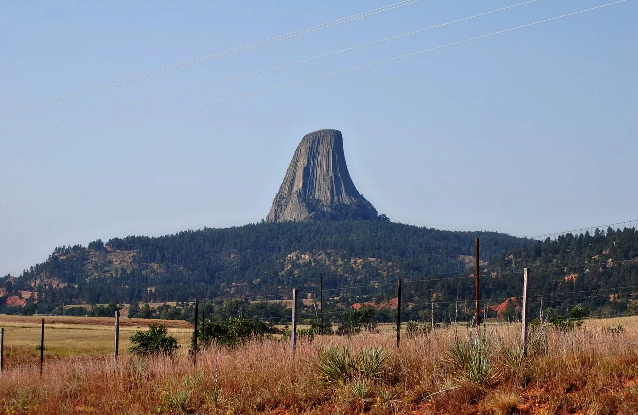 a tall mountain towering over a lush green field