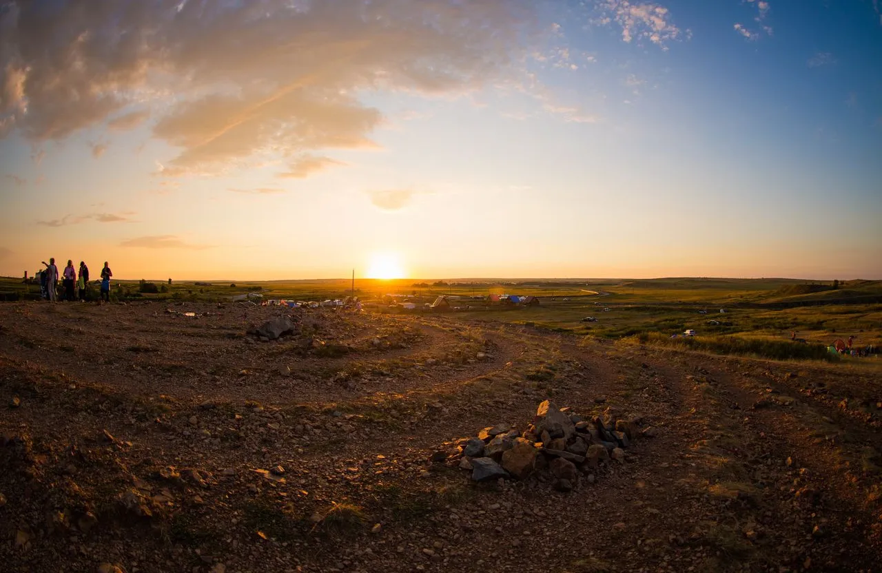 a group of people standing on top of a dirt field