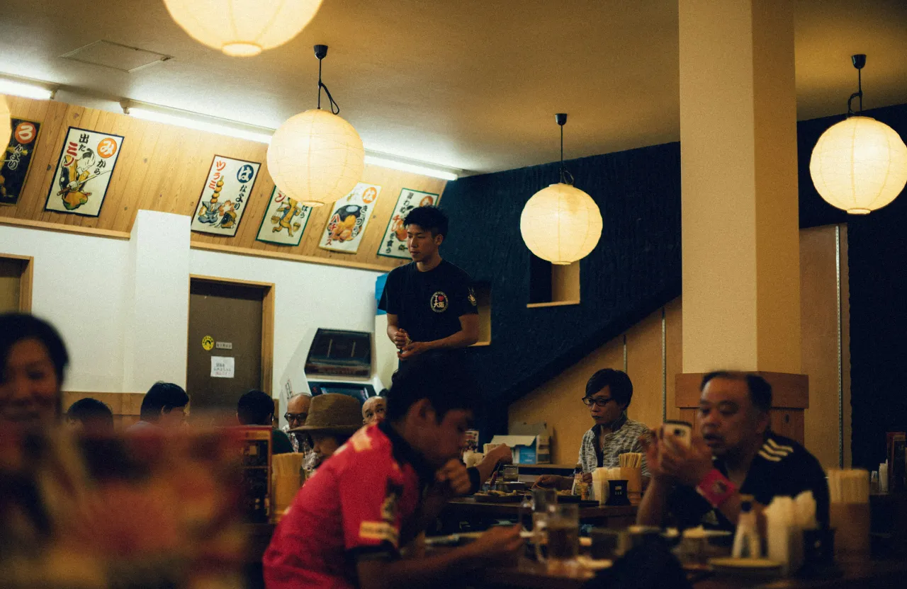 a group of people sitting at a table in a restaurant near of Osaka Japan