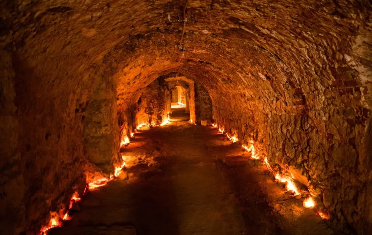 a long tunnel with lit candles inside of it