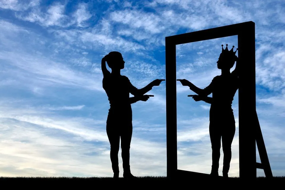 a silhouette of woman standing in front of a mirror