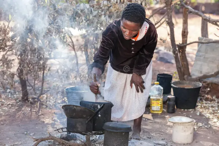 an African woman cooking food with minimum utensils