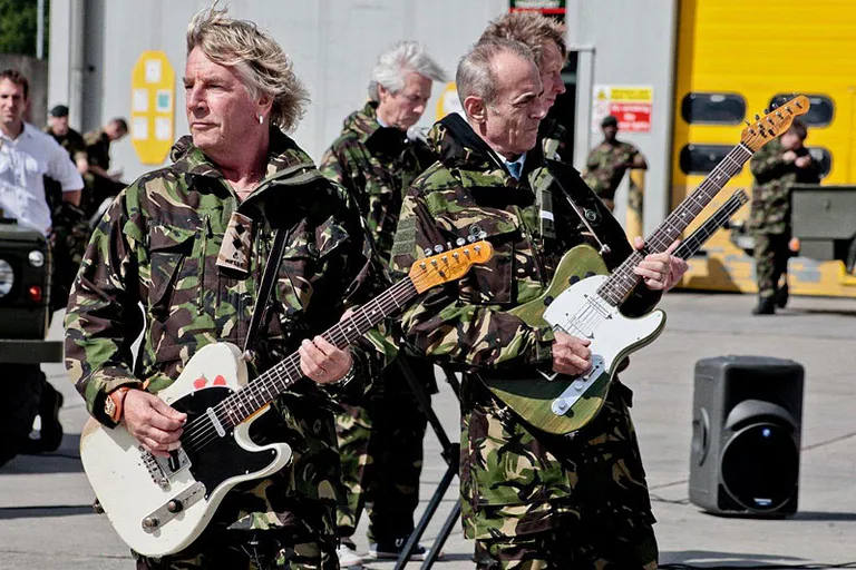 a group of men in camouflage playing guitars