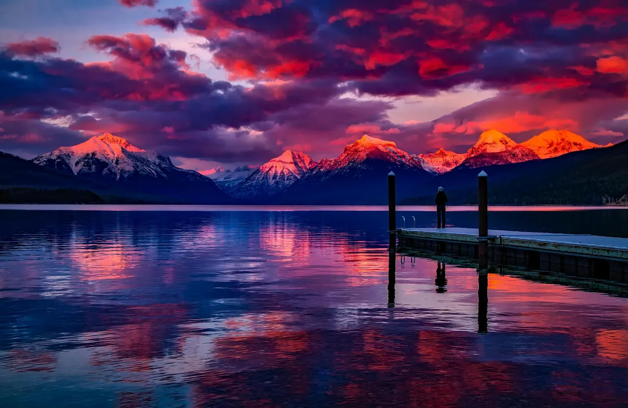 A cinematic drone shot of the sunset over the lake and mountains