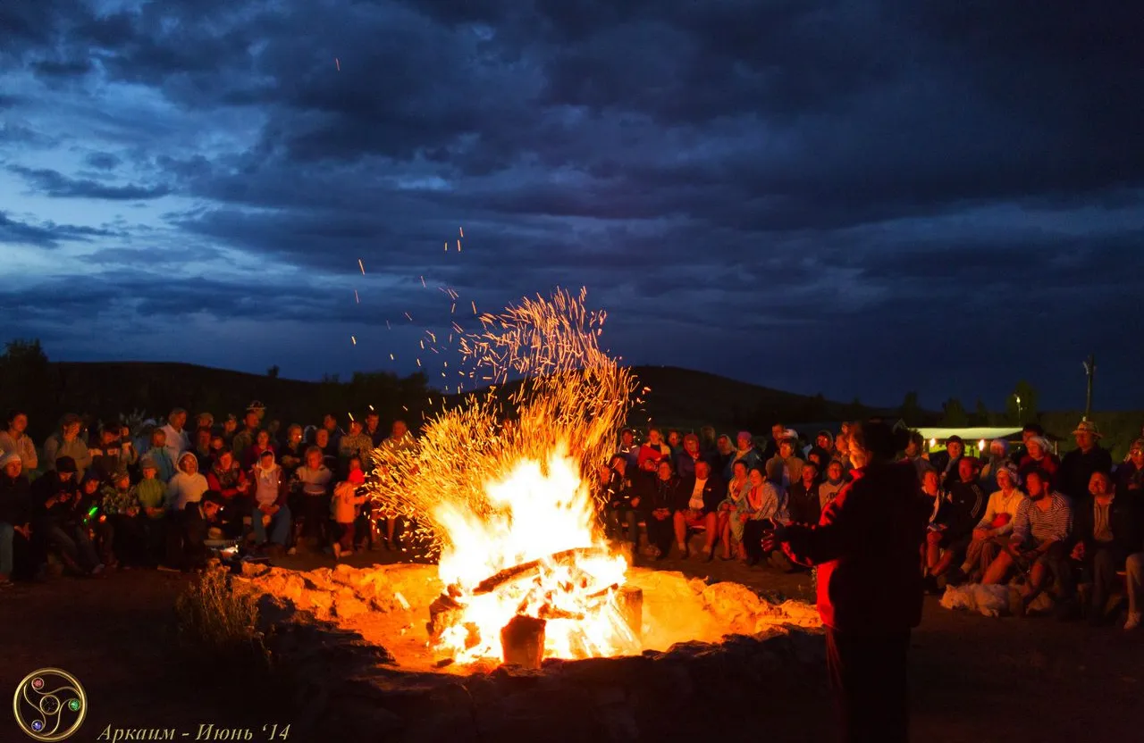 a group of people sitting around a fire pit