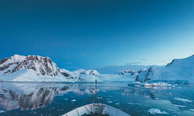 a boat on a body of water with mountains in the background