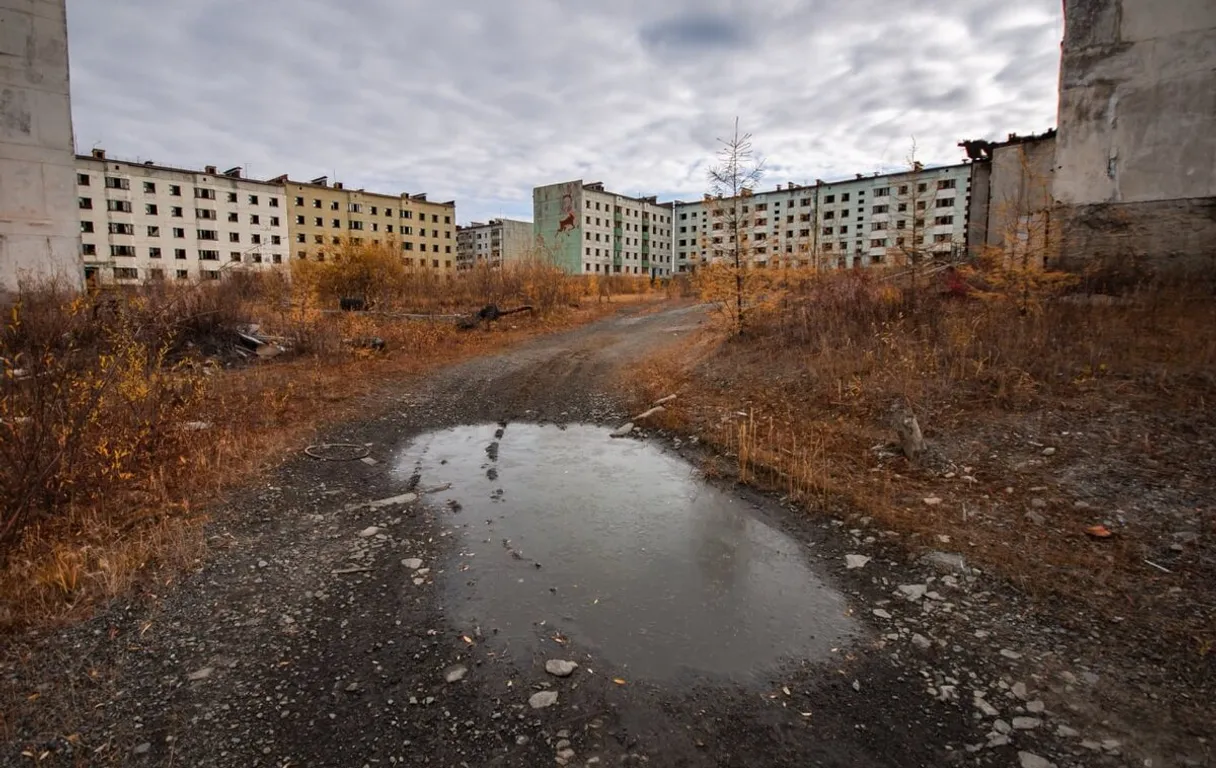 an abandoned building with a puddle of water in the middle of it